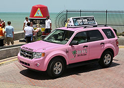 A new Five Sixes Taxi hybrid vehicle rolls past the Southernmost Point marker Wednesda in Key West, Fla. (Photos by Rob O'Neal/Florida Keys News Bureau)